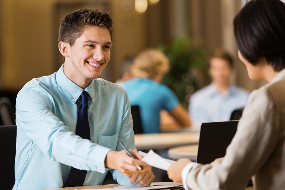 Young man submitted paperwork in office setting