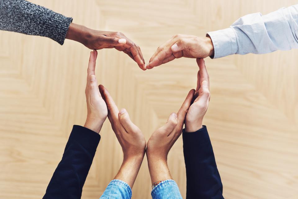 business people use hands to form the shape of a heart